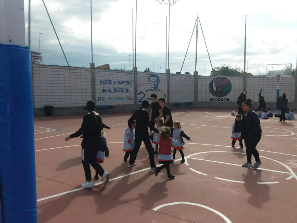 Kinder spielen auf einem Sportplatz Ball.